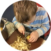 One of the Little Acorns Nursery children peeling potatoes for January's Recipe of the Month. One of the Little Acorns Nursery children peeling potatoes for January's Recipe of the Month.