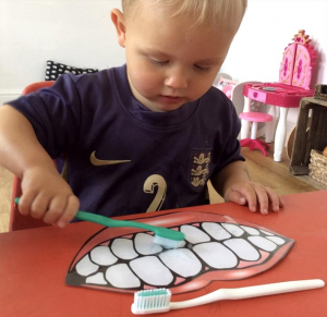boy-practises-brushing Young boy practises brushing giant teeth.
